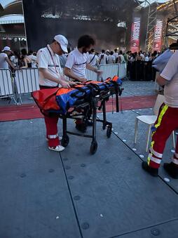 preparation-brancard-assistance-medicale-concert préparation d'un brancard par deux personnes du corps médical dans le cadre d'une assistance médicale événementielle pour un concert en stade sportif